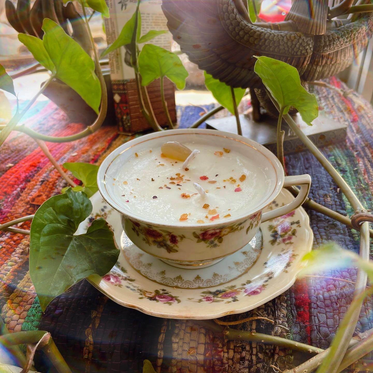 A small teacup with an herbal and scented candle inside it