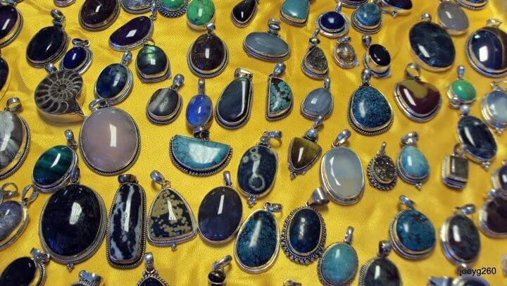 A display of various gemstone pendants set in sterling silver