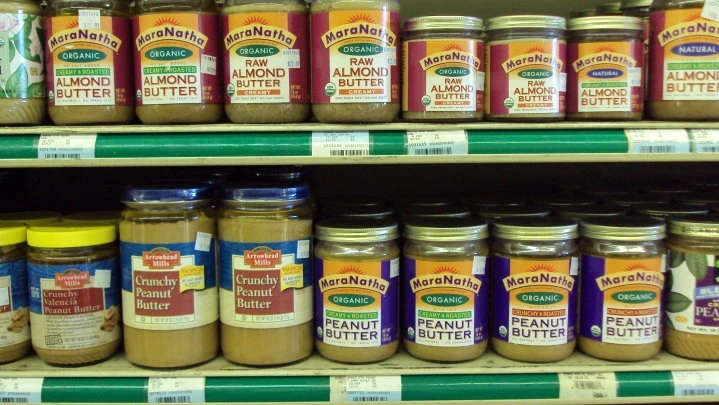 A shelf of peanut butter jars
